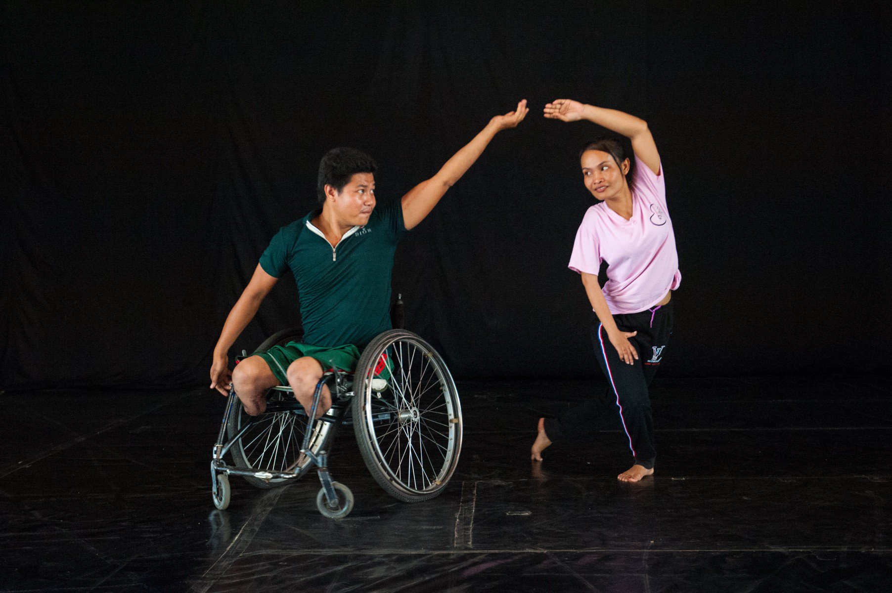 A man in a wheelchair and a women are dancing together.