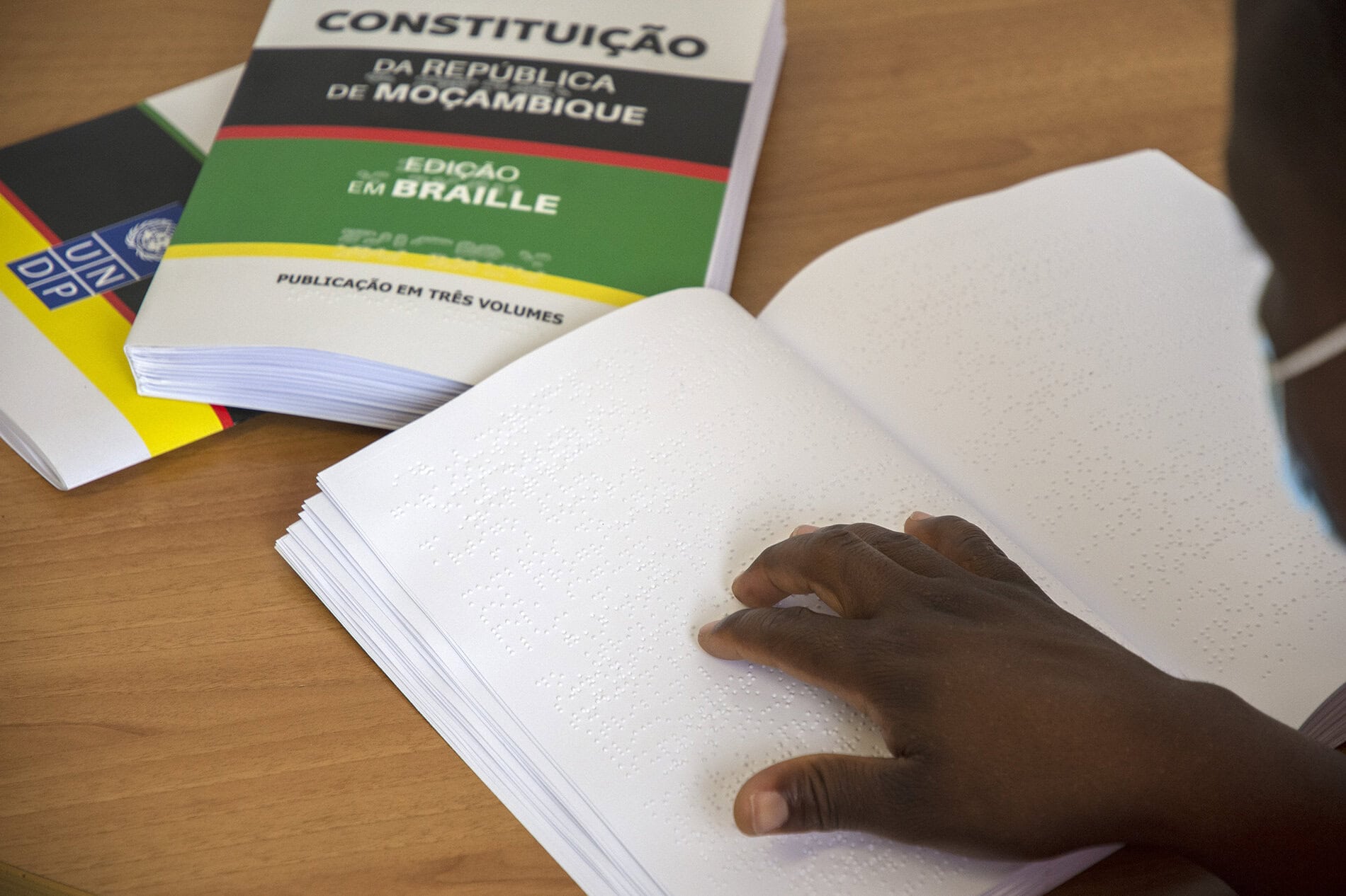 Picture of someone using a braille book to vote at a voting center.